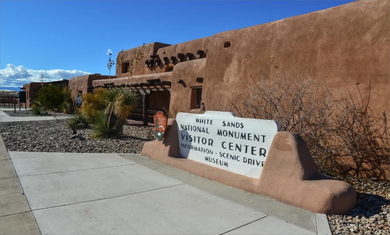 An adobe building with an adobe sign in front of it, located near White Sands National Park.
