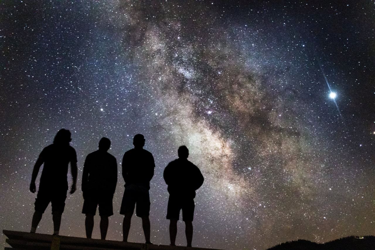 People standing looking at the night sky and milkyway