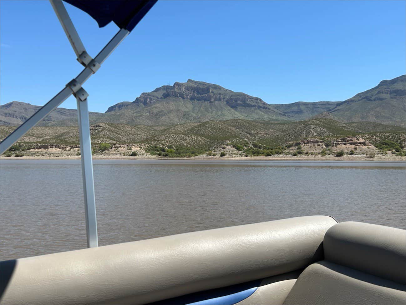 A boat on Caballo Lake with mountains in the background at State Park.