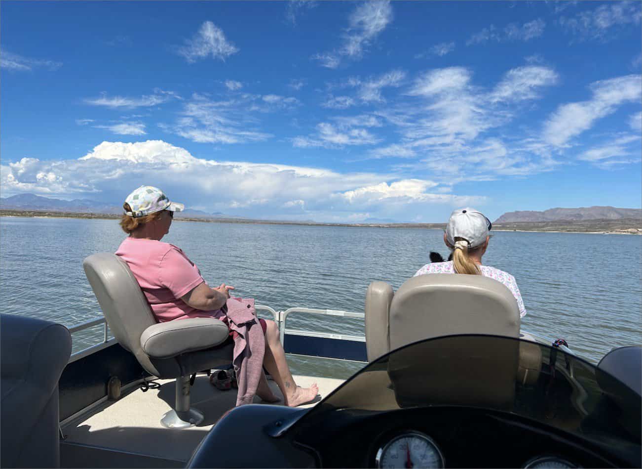 Two women sitting in the back of a boat on a lake in New Mexico.