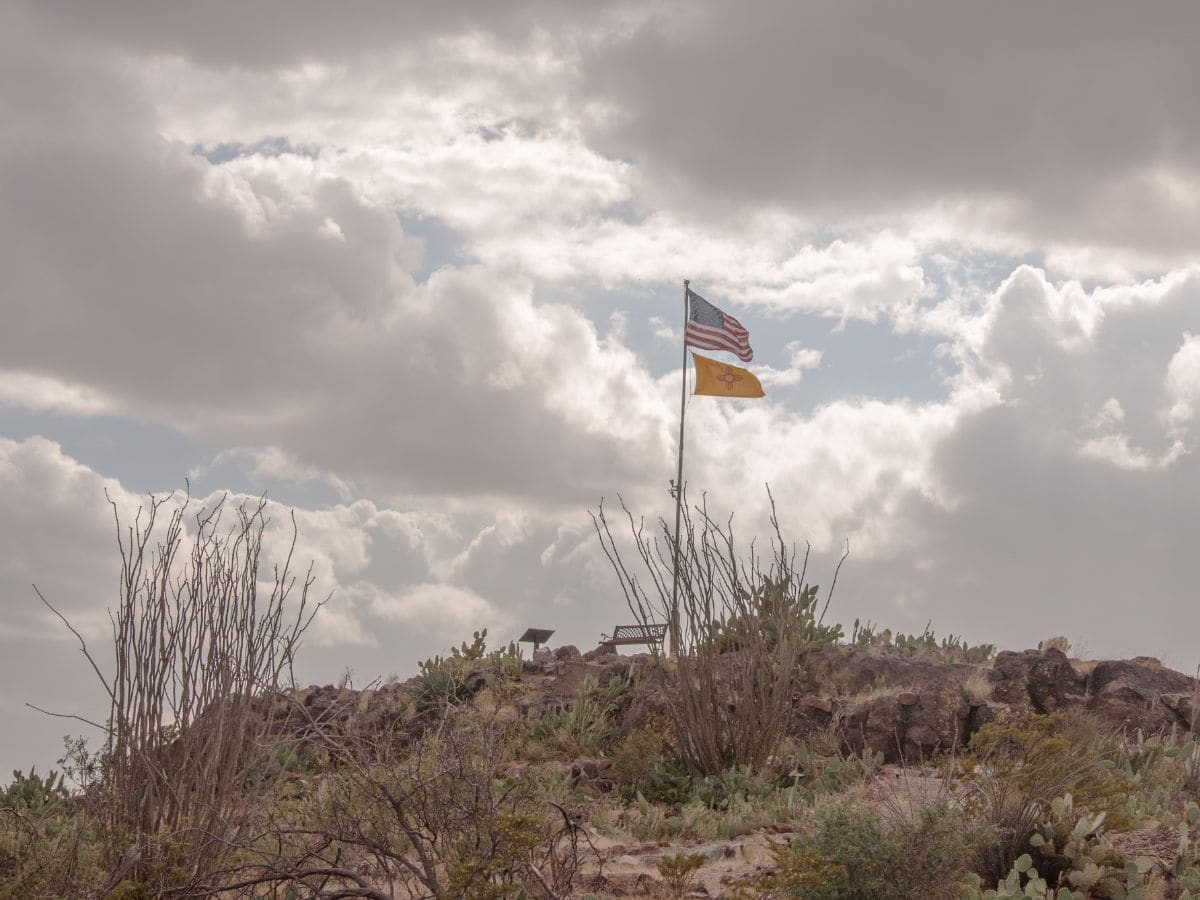A flag flies atop a rocky hill at Pancho Villa State Park.