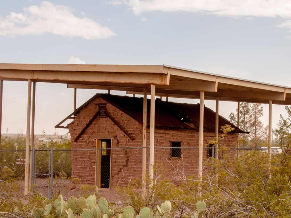 A small house with a roof in the desert, located in Pancho Villa State Park.