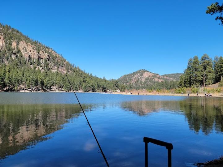 Enjoy a tranquil day fishing at Fenton Lake State Park, surrounded by picturesque mountains.