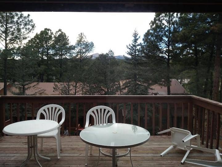 A deck with two chairs and a table at the RV Park, overlooking the mountains.
